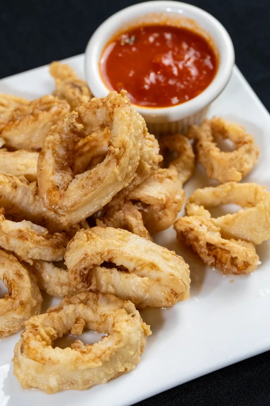 Close-up of crispy fried calamari with lemon and marinara
