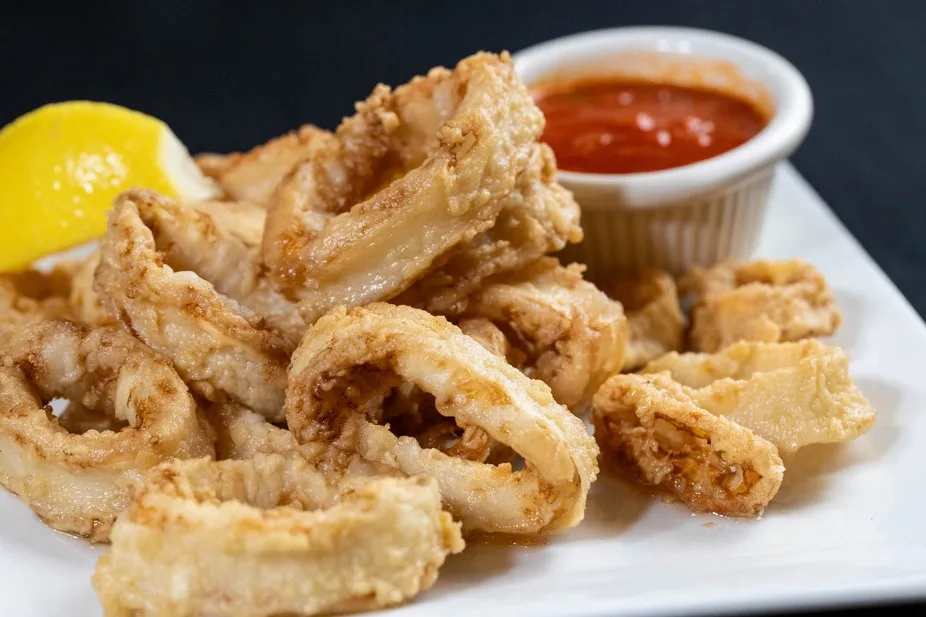 Golden fried calamari served with a side of marinara sauce